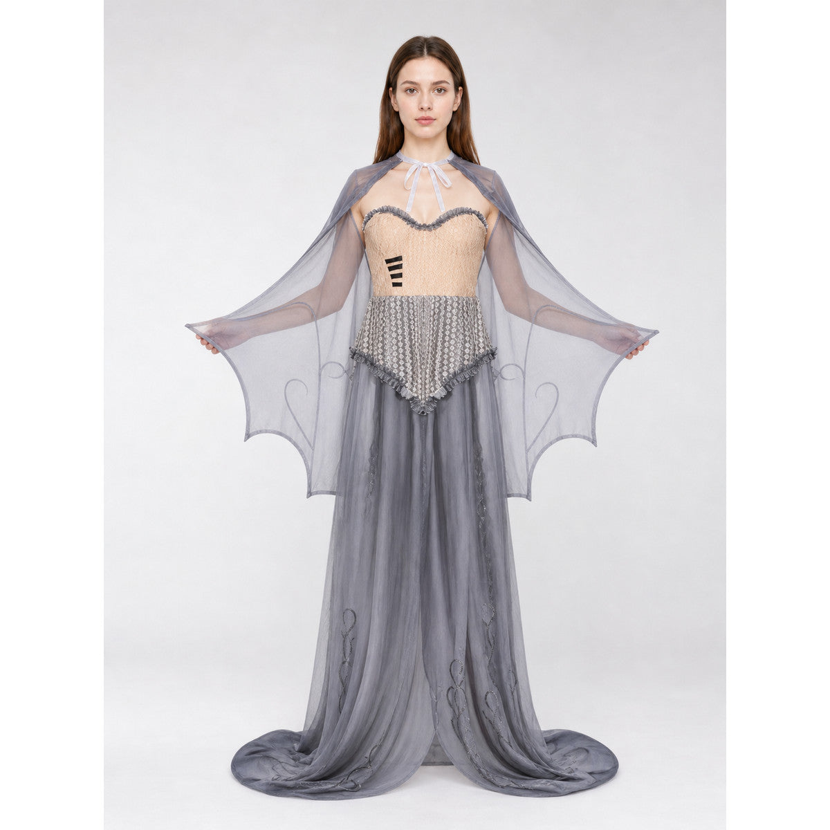 Woman wearing the gothic zombie costume: beige corset-style strapless bodice, long gray sheer skirt and a sheer gray bat-wing cape, front view