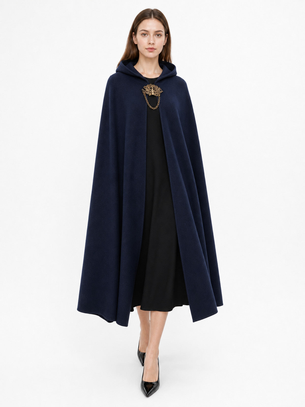 Navy hooded costume cloak shown full-length on a model with the hood down, smooth draping fabric, and ornate front clasp over a black dress