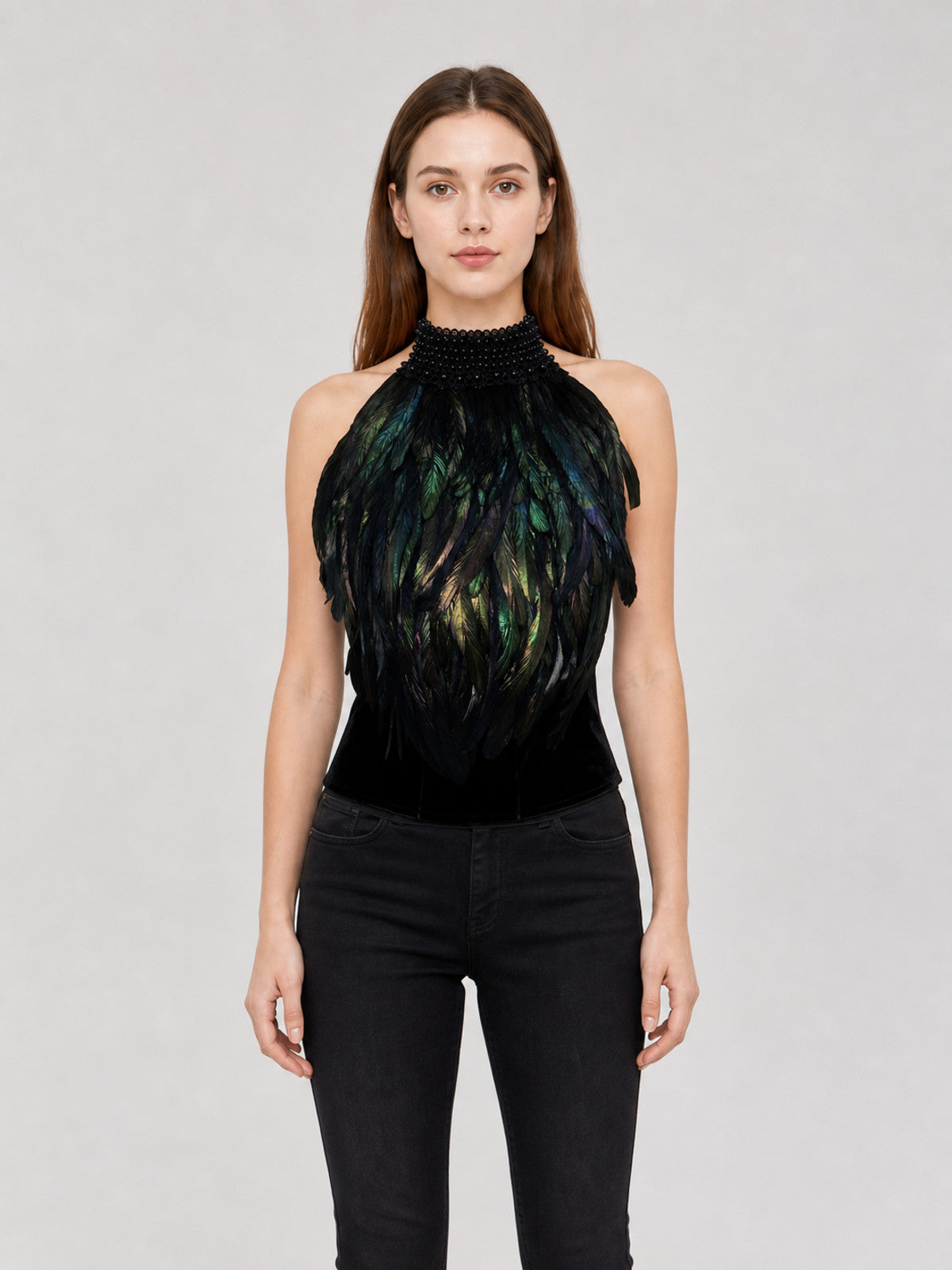 Black halter top with iridescent green and blue feathers and a beaded high collar, shown front-facing on a model