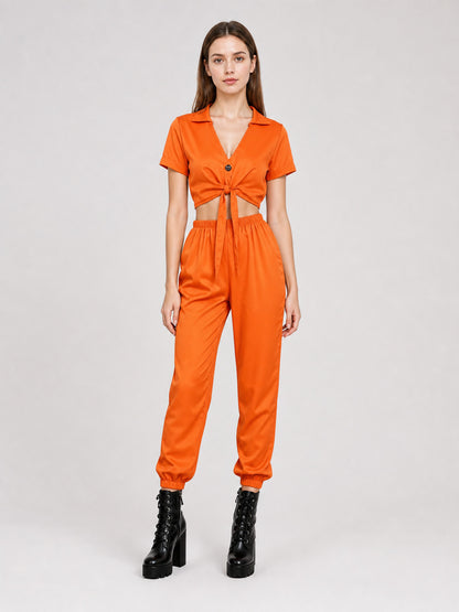 Orange two-piece set with a collared tie-front top and elastic-cuff jogger pants, shown full-body on a woman
