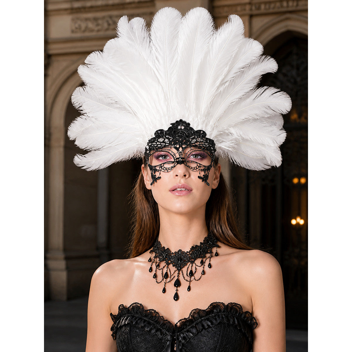 White feather headpiece with a black lace mask, shown in a close-up portrait on a model wearing black costume clothing
