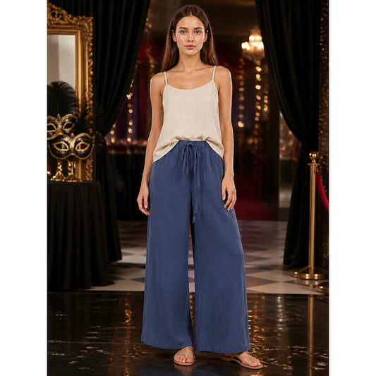 Navy wide-leg pants with a drawstring waist and side pockets, shown full-body on a model with a cream camisole