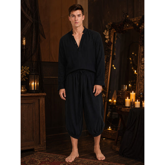Black cropped pants with a loose fit and elastic ankle cuffs, shown full-body on a barefoot model indoors