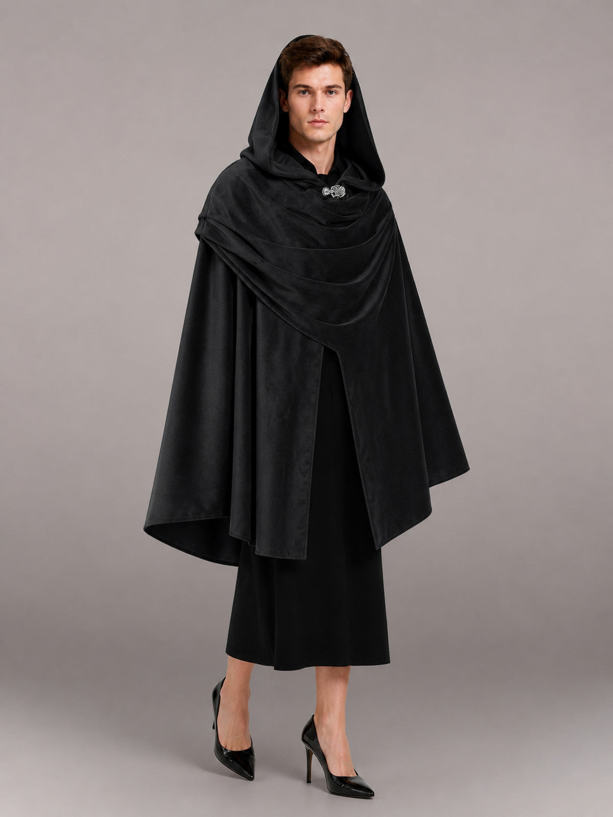 Black hooded cloak with layered draping and front clasp, shown full-body on a model over a black dress