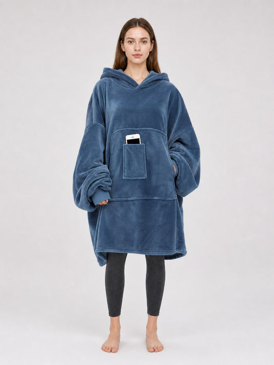 Blue plush fleece hooded blanket hoodie shown full-body on a model, with oversized sleeves and a front pouch pocket holding a phone