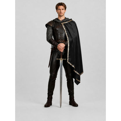 Black medieval costume shown full-body on a model, with a leather-look vest, chainmail sleeves, hooded cape, gold trim, trousers, boots, and sword