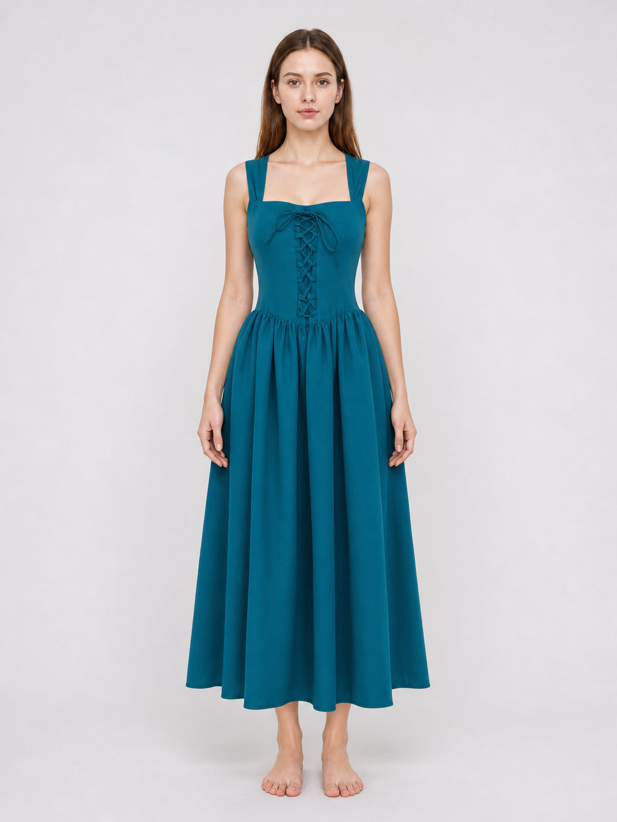 Teal sleeveless dress with wide straps, fitted lace-up bodice, gathered waist, and long flowing skirt shown full-body on a model