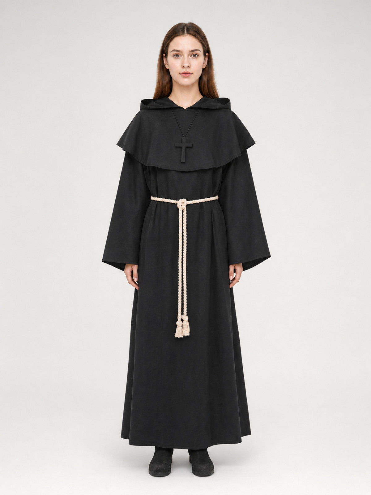 Black hooded monk robe on a full-body model, with a shoulder cape, cross pendant, wide sleeves, and cream rope belt