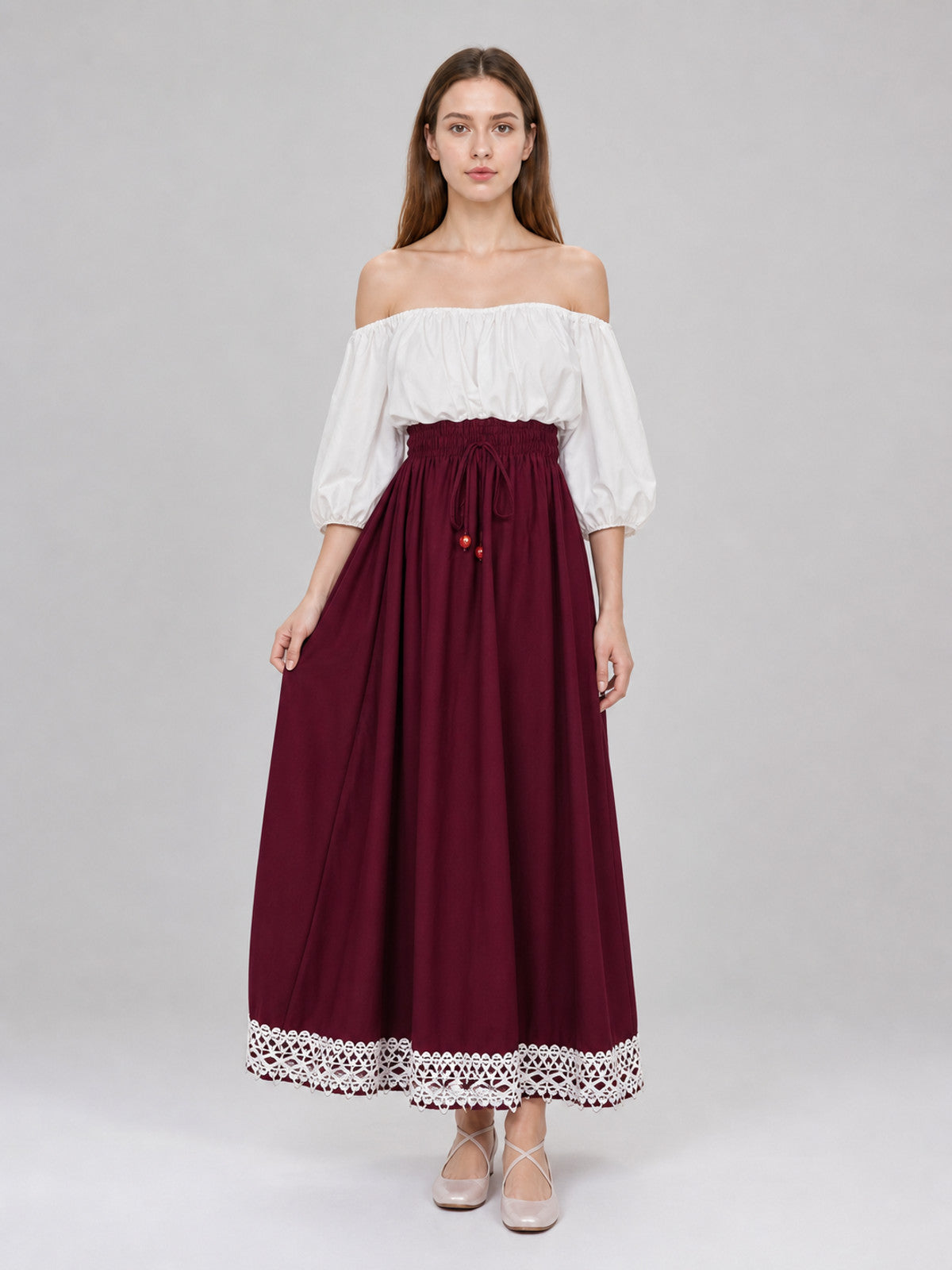 Burgundy ankle-length A-line skirt on a full-body model, with a gathered waistband, front drawstring, and white lace trim