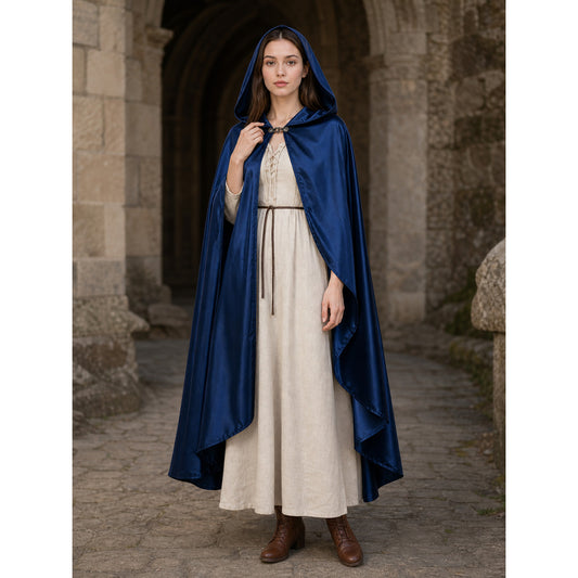 Blue satin-look hooded cape worn full-body over a cream dress, with a front clasp and draped pointed hem