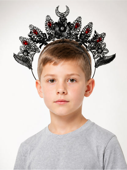 Gothic horned headpiece in black and silver tones with red stones, filigree details, and pearl-like beads, shown on a child in a front portrait