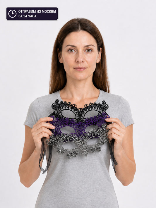 Black, purple, and silver lace masks held in front of a woman wearing a gray T-shirt