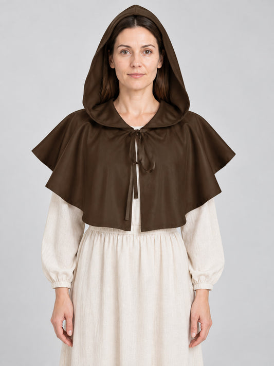 Woman wearing a short brown hooded capelet tied at the neck over a cream medieval dress, front view