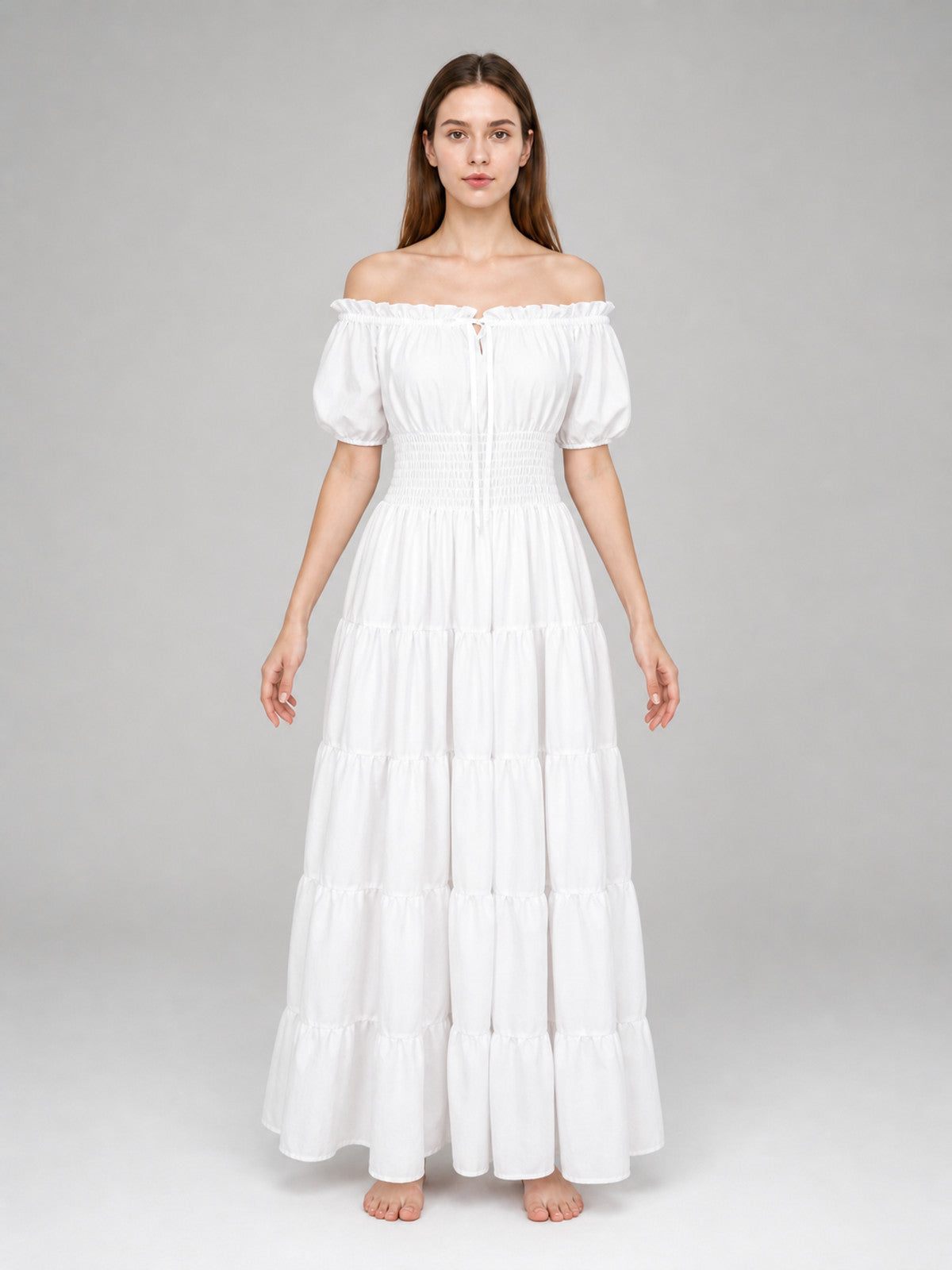 White off-shoulder maxi dress on a full-body model, with short puff sleeves, gathered waist, and multiple tiered skirt panels