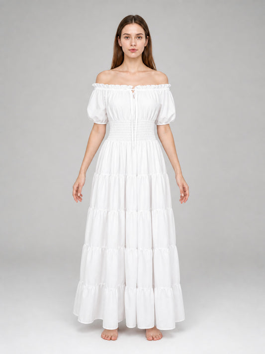 White off-shoulder maxi dress on a full-body model, with short puff sleeves, gathered waist, and multiple tiered skirt panels