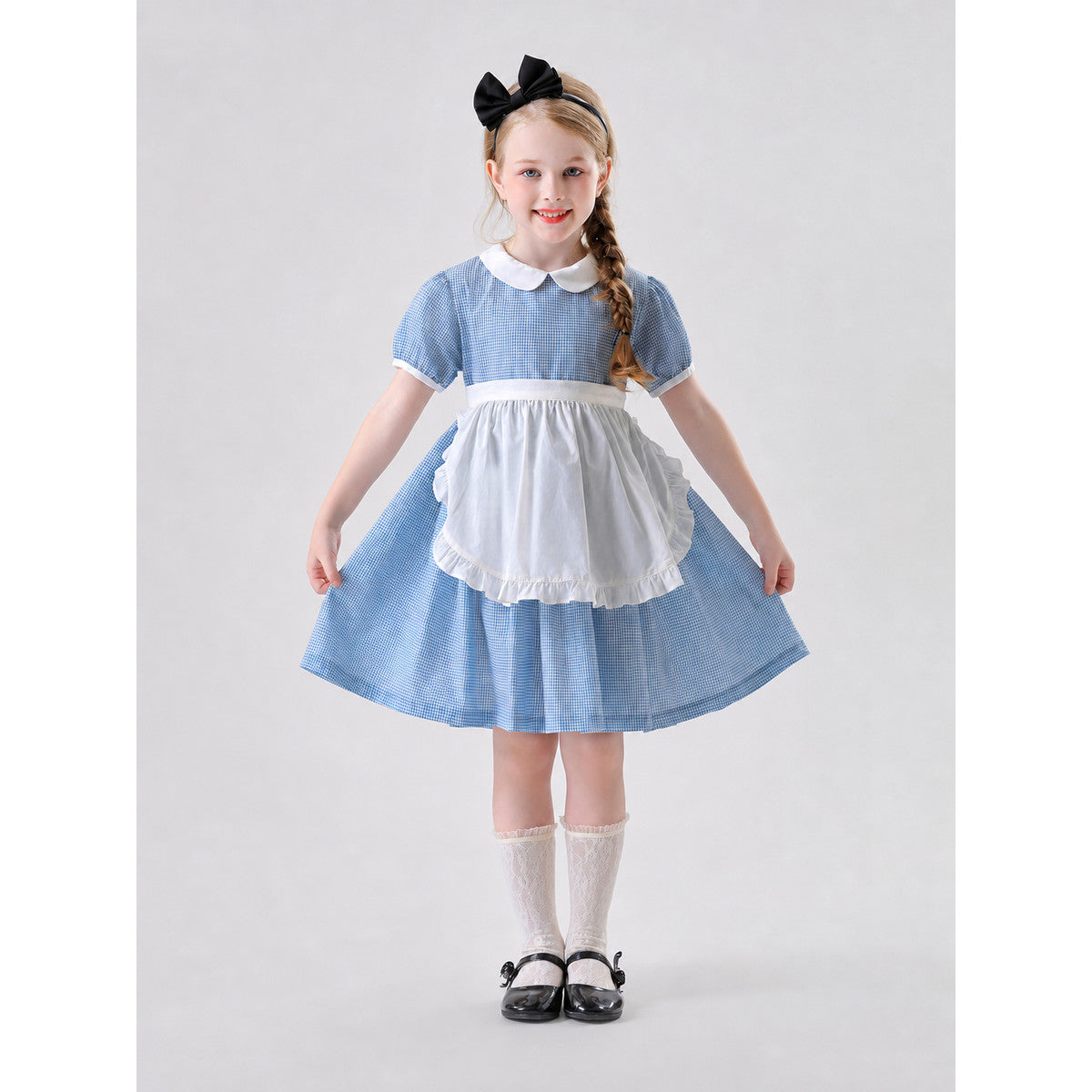 The dress is designed in a retro style, combining a blue-and-white small check pattern with distinctive white details. A white apron-like insert is featured on the front, while the white Peter Pan collar and white waist detail reinforce the