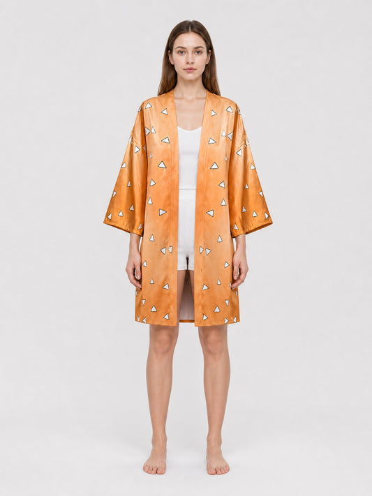 Full-body model wearing an orange satin-look robe with wide three-quarter sleeves and scattered white triangle pattern