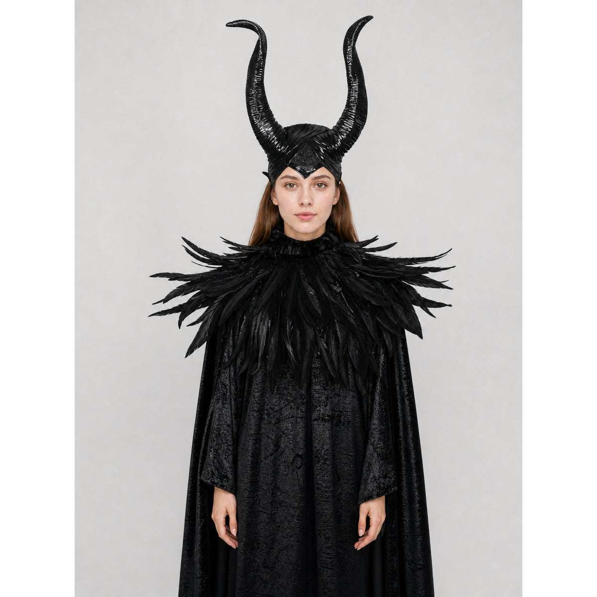 Black horned headpiece and feather-trimmed cape shown full-body on a woman against a plain studio background