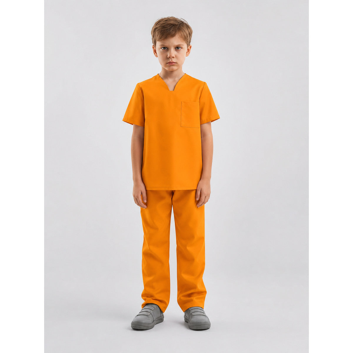Full-body front view of a child wearing an orange short-sleeve shirt with a chest pocket and matching pants in a studio
