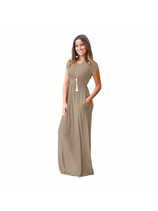 Woman wearing a khaki short sleeve maxi dress with an elastic waist, hands in the side pockets, front view