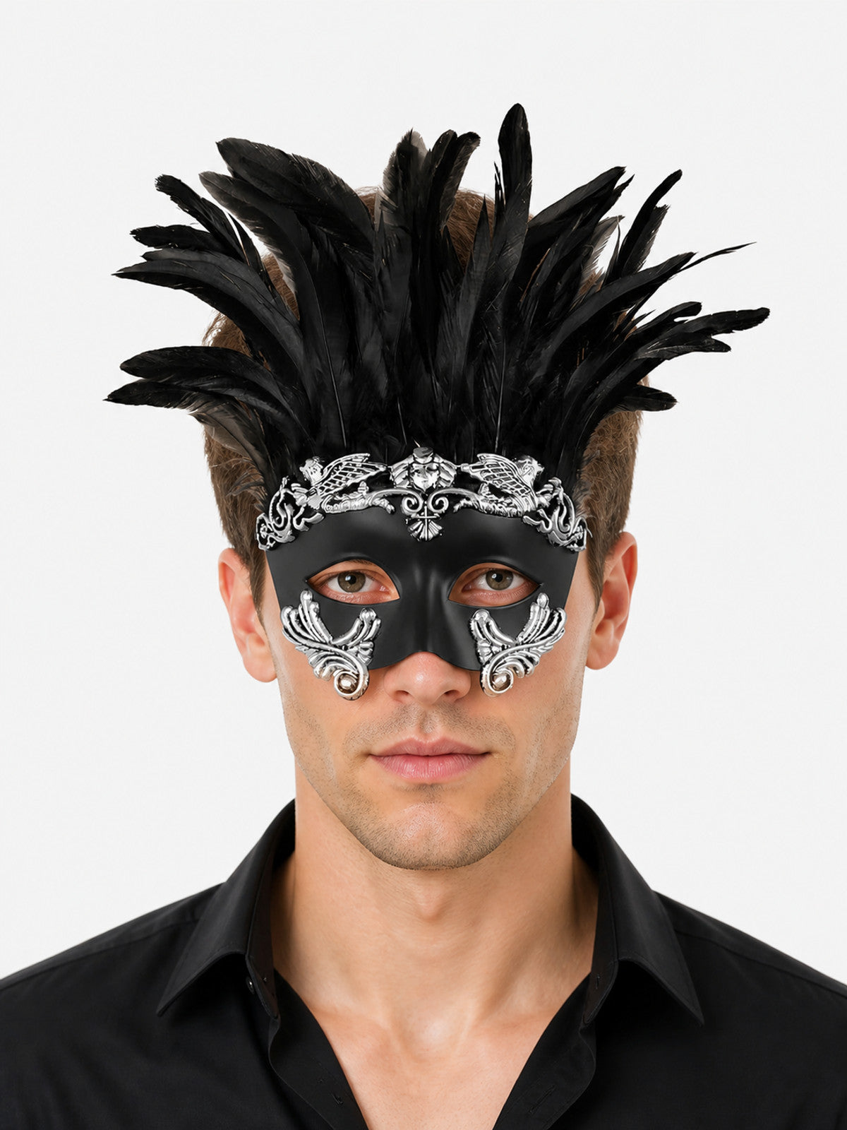 Black feather masquerade mask with silver ornamental details shown close-up on a man against a plain light background