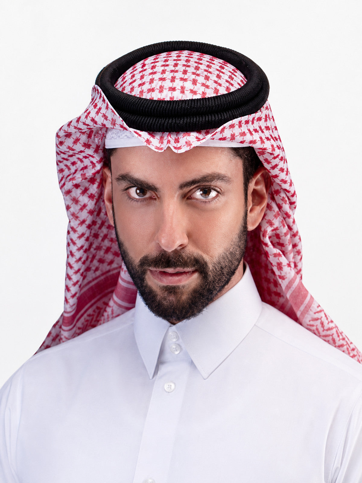 Close-up of a man wearing a red-and-white patterned scarf with a black circular headband over a white collared shirt