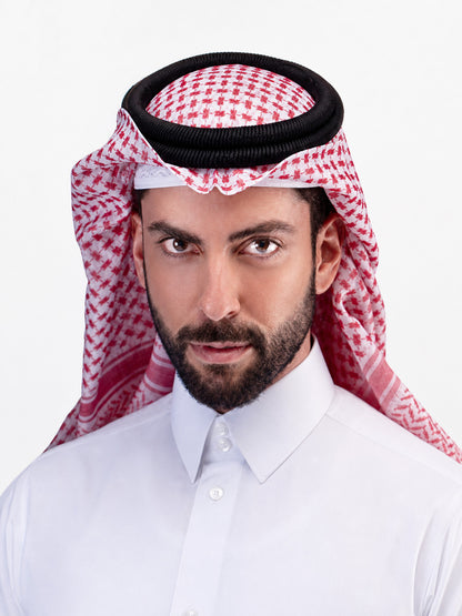 Close-up of a man wearing a red-and-white patterned scarf with a black circular headband over a white collared shirt