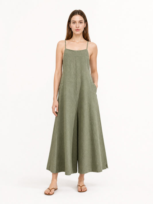 Olive green wide-leg jumpsuit with thin shoulder straps and side pockets, shown full-body on a model against a white studio background