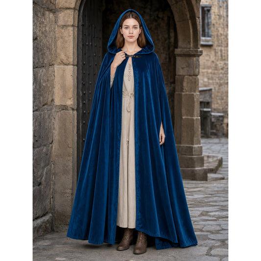Dark blue velvet hooded cloak shown full length on a model in a stone archway, worn over a light dress