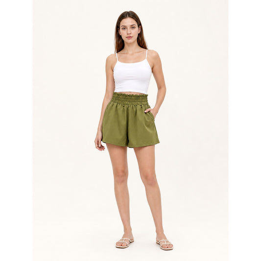 Olive green shorts on a full-body model, showing a high gathered waistband, side pockets, relaxed legs, and lightweight smooth fabric