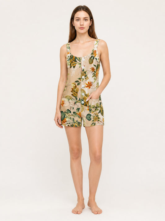 Full-body model wearing a beige floral romper with shoulder straps, front buttons, and side pockets