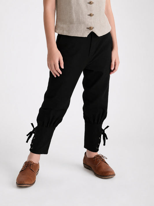 Black loose-fit pants shown on a model, with gathered ankle cuffs, side ties, and brown lace-up shoes