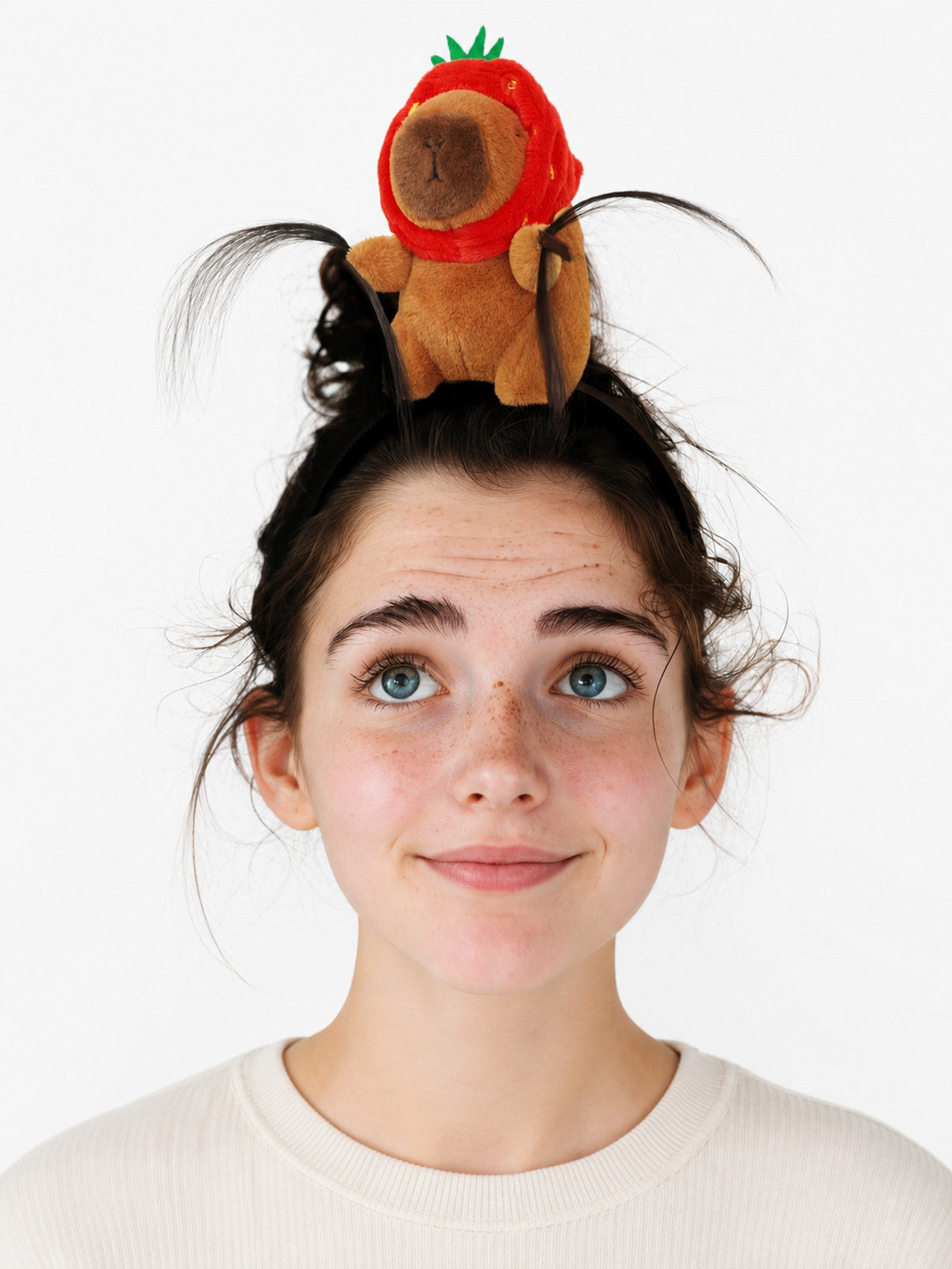 Plush costume headband shown on a model, with a brown animal figure in a red strawberry hood, green leaves, and black curved strands