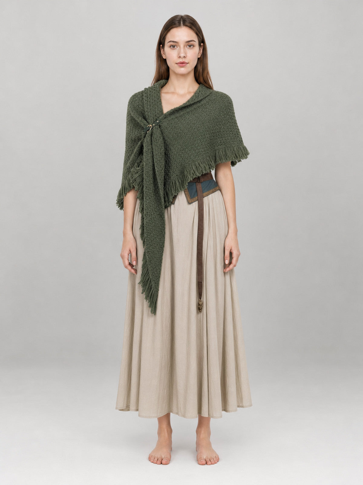 Olive green knitted shawl with long fringe, shown full-body on a model over a beige dress