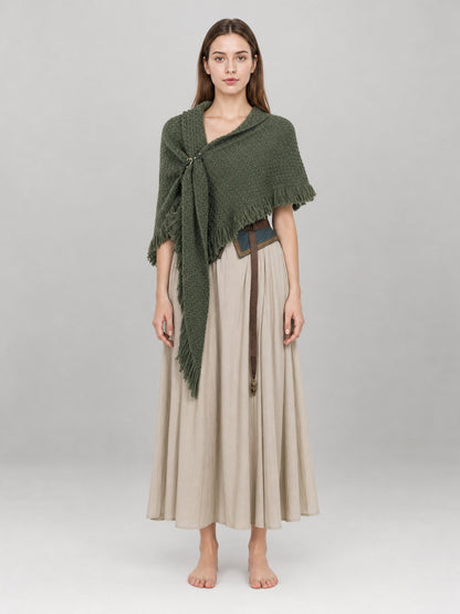 Olive green knitted shawl with long fringe, shown full-body on a model over a beige dress