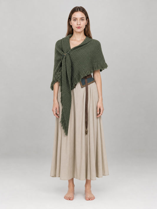 Olive green knitted shawl with long fringe, shown full-body on a model over a beige dress
