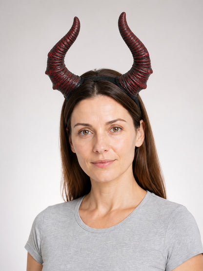 Horn headband with two curved red and black textured horns, shown in a front-facing portrait on a model