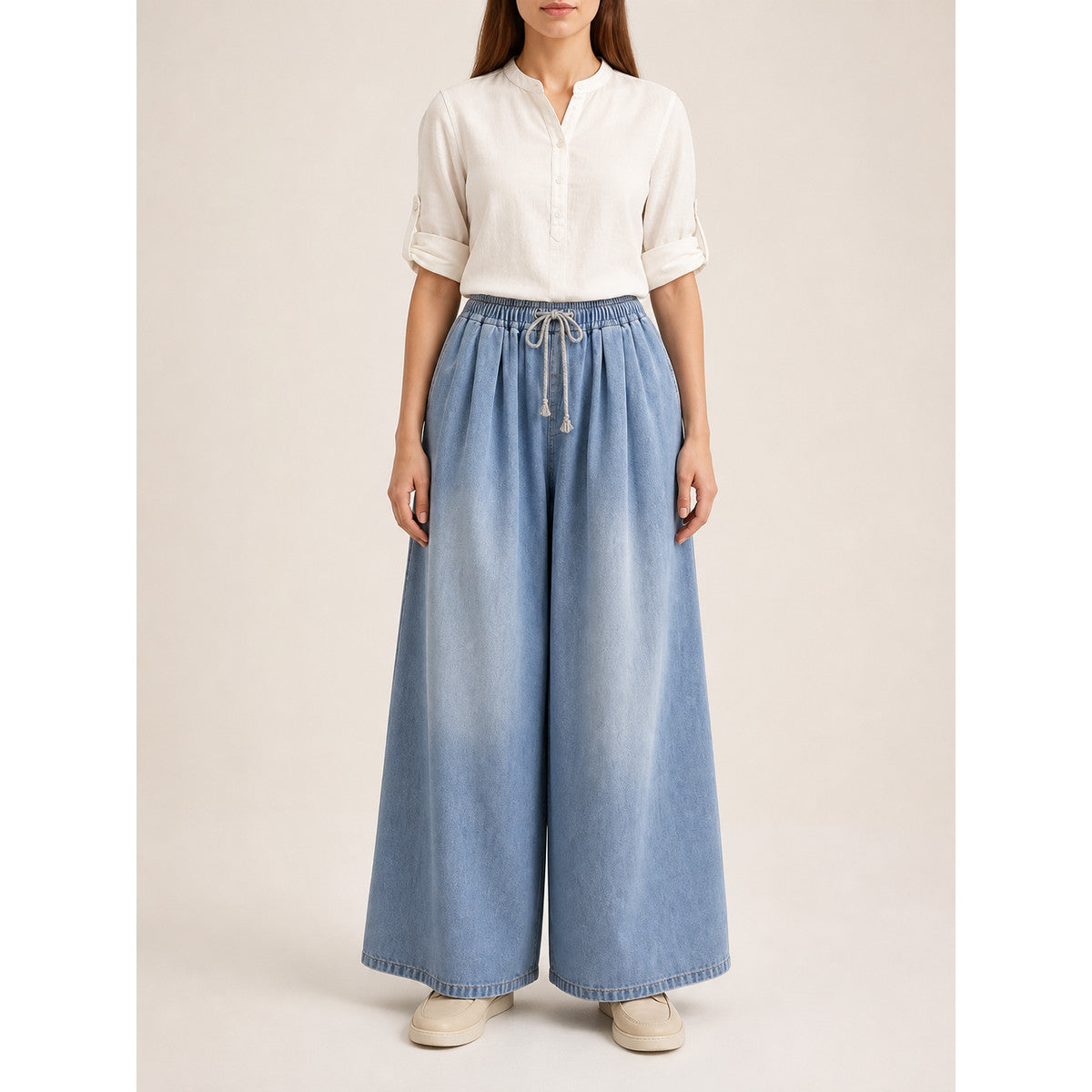 The model features a relaxed style with very wide, full-length legs that create a laid-back silhouette and suit everyday looks. The light blue shade with a subtle denim-like effect makes the piece versatile for warm weather and easy to pair