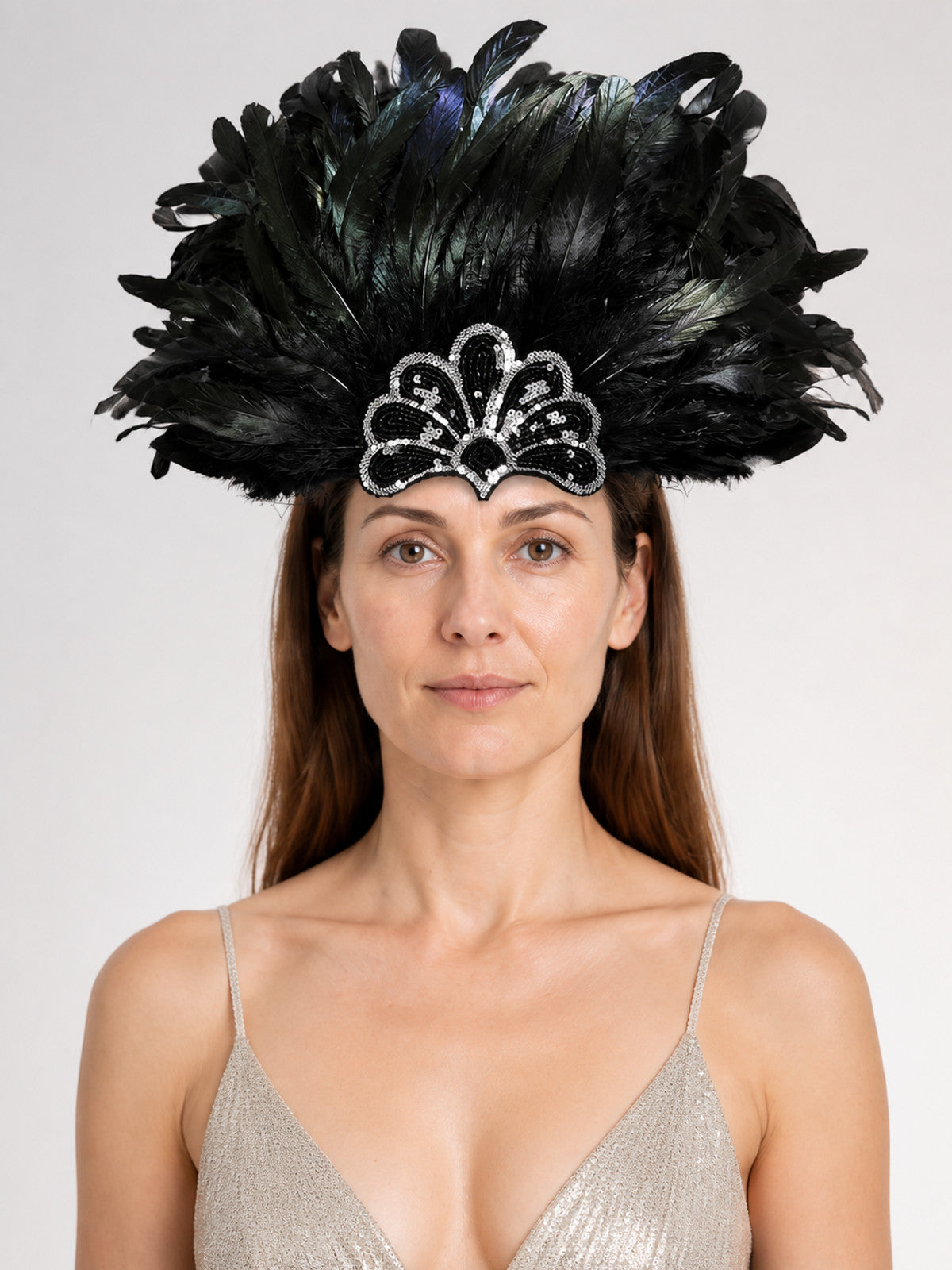 Black feather headpiece with a silver-trimmed sequin ornament, shown in a front-facing close portrait on a model