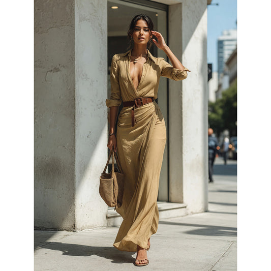 The dress features a long khaki silhouette with long sleeves, a shirt-style collar, and a crossover wrap front. The wrap construction creates a distinctive front line, while pleats at the waist add noticeable texture to the design. The fit 