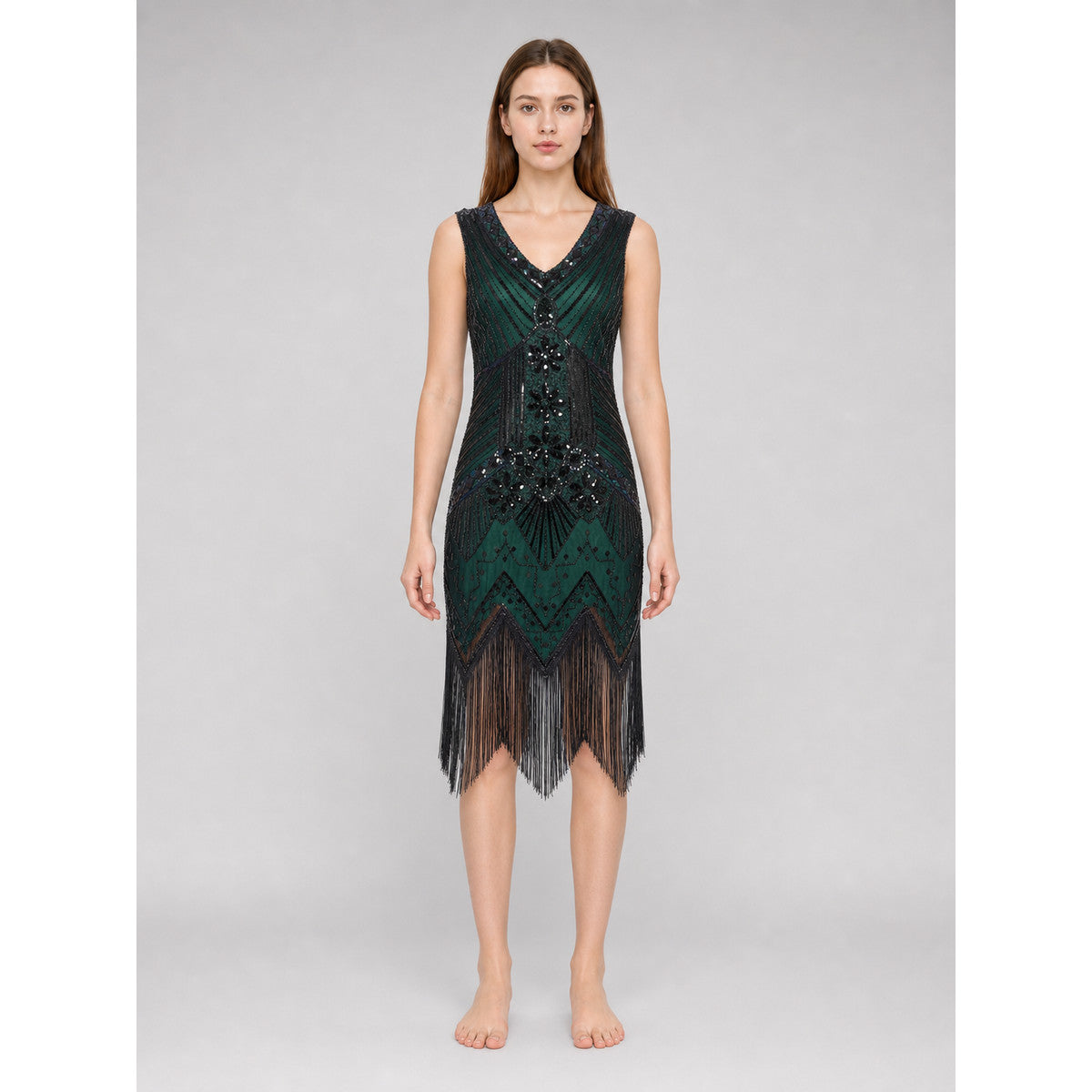 The flapper dress is designed in the Art Deco aesthetic and conveys the signature look of the Gatsby era. The sleeveless design features a V-neckline and a straight silhouette. A geometric and fan-shaped pattern covers the entire surface, c
