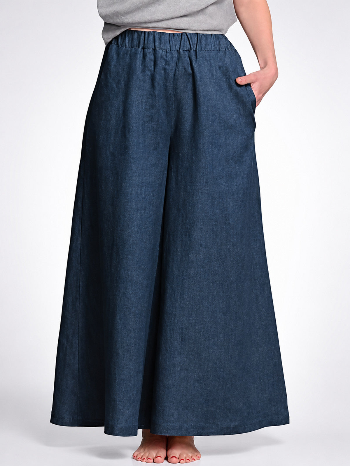Dark blue wide leg pants with an elastic waistband and side pocket, shown in a close front view on a model
