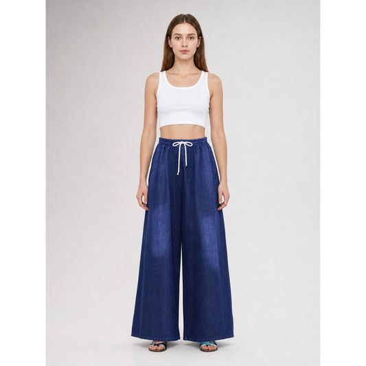 Dark blue wide-leg pants with a white drawstring, shown full-length on a model wearing a white crop top and sandals