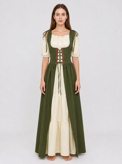 Full-body model wearing a green and cream dress with a laced bodice, puff sleeves, shoulder ties, and a layered skirt