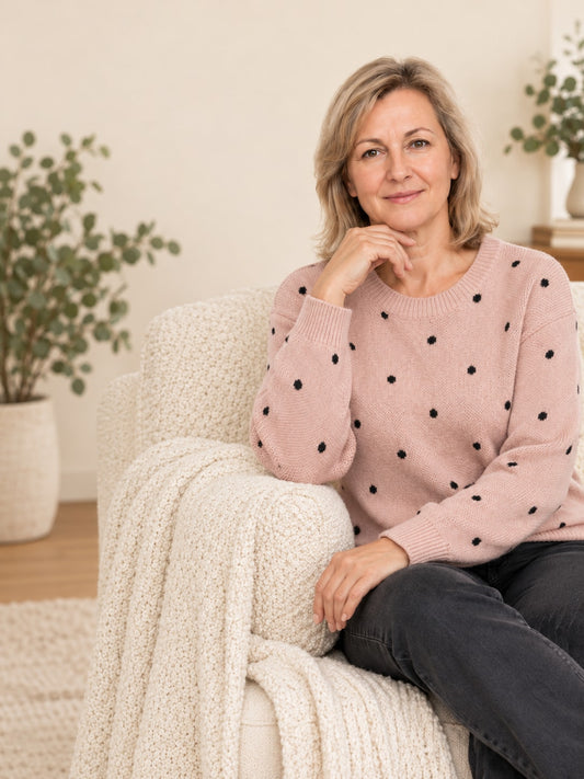 Women's pink polka dot knit crew-neck sweater – front view, seated