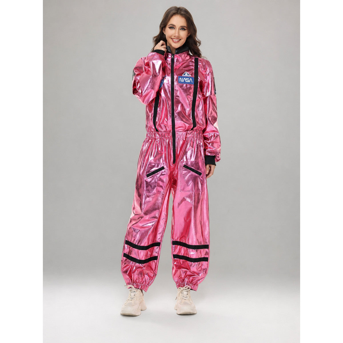 The pink NASA astronaut costume is designed as a one-piece jumpsuit with long sleeves, a stand-up collar, and a central zip closure. The model is pink with black decorative elements: a vertical stripe on the front, zippered side pockets, ho