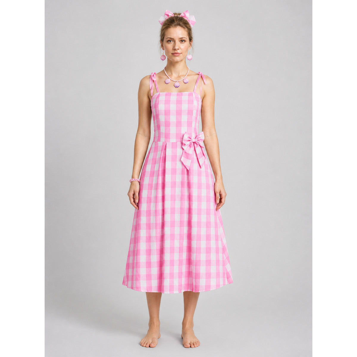 Pink-and-white gingham pinafore dress with a bow on-model view
