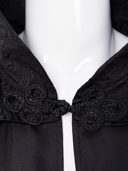 Close-up of the braided frog-knot closure and jacquard stand collar on the black cape