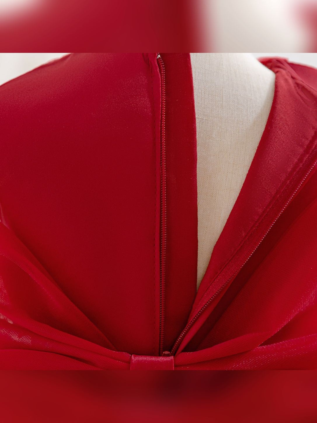 Close-up of the back zipper and bow on the girls' red princess dress