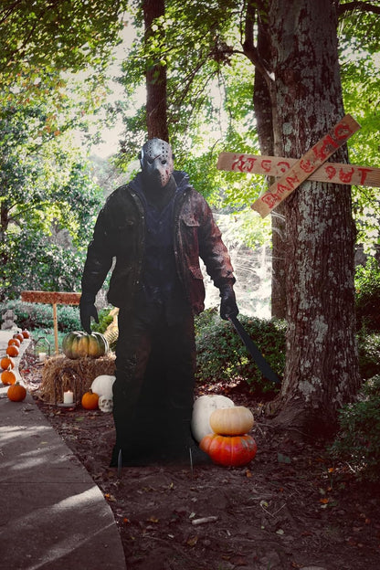 Life-size Jason horror cutout standee in a Halloween front yard